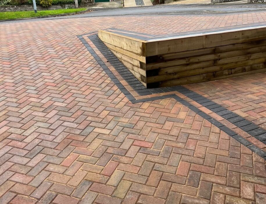 Herringbone block paving driveway with charcoal border and timber sleeper retaining wall in a Wiltshire cul-de-sac