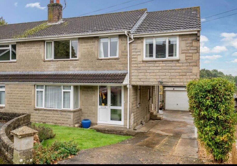 Stone-built semi-detached house with an old plain driveway before block paving installation