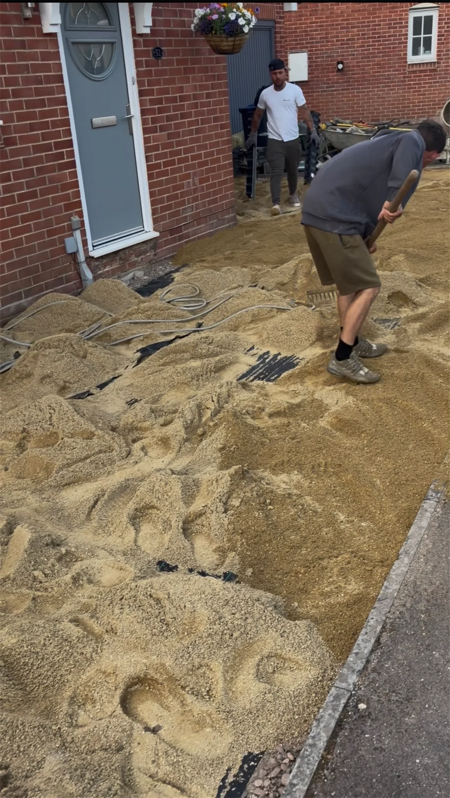 Team laying and compacting MOT Type 1 sub-base ready for block paving, Trowbridge